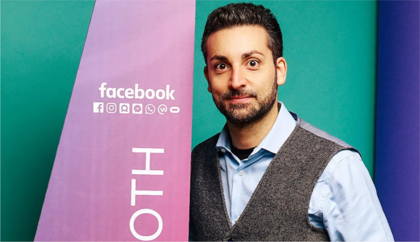 Andy Grava in front of Facebook branding
